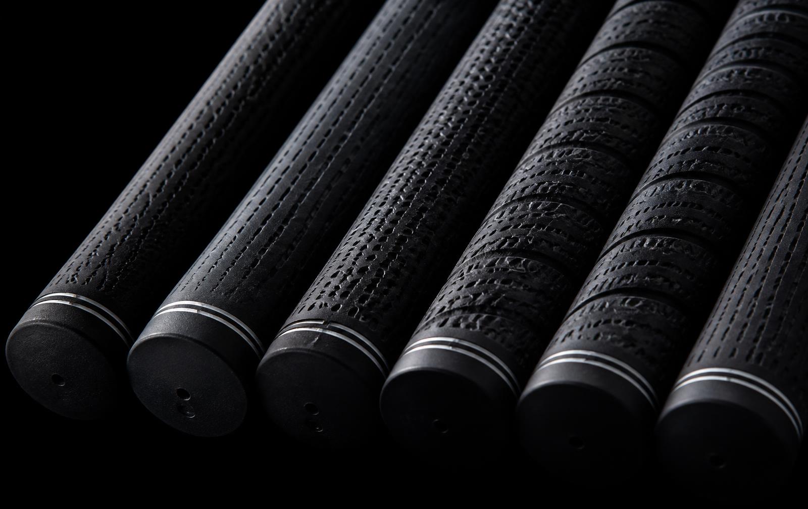 Row of textured golf grips lit from the side
