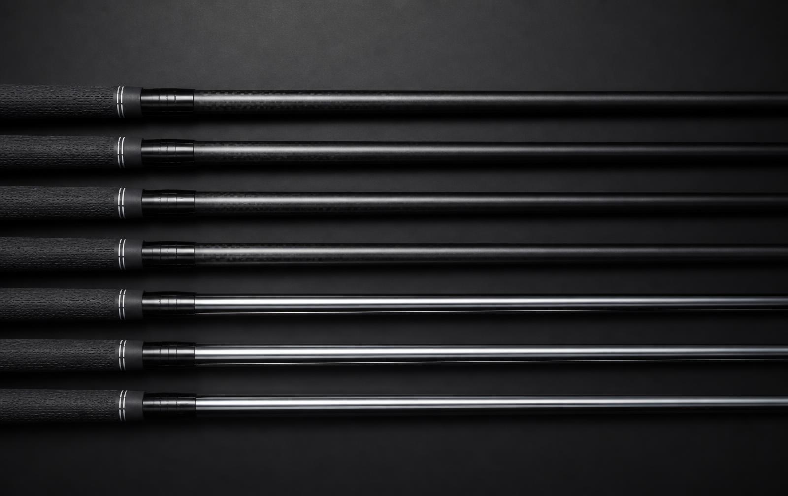Graphite and steel golf shafts laid out in a precise row